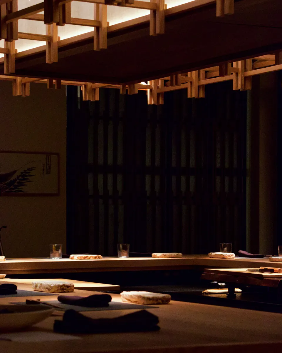 The Omakase Bar in the evening, the counter set beneath the lattice ceiling