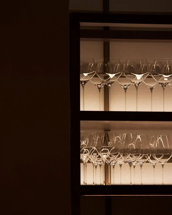 Wine glasses on backlit shelves