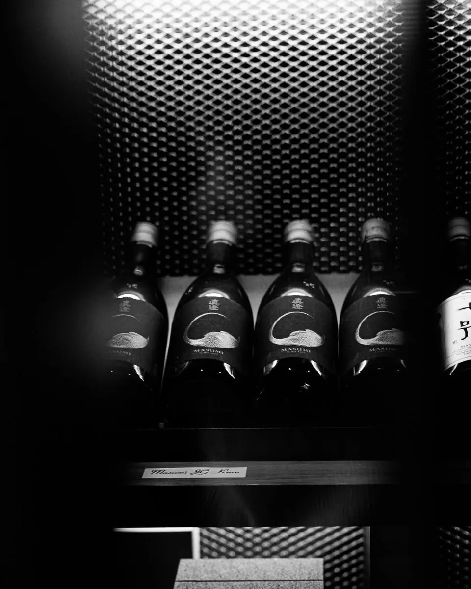 Sake bottles on a backlit shelf